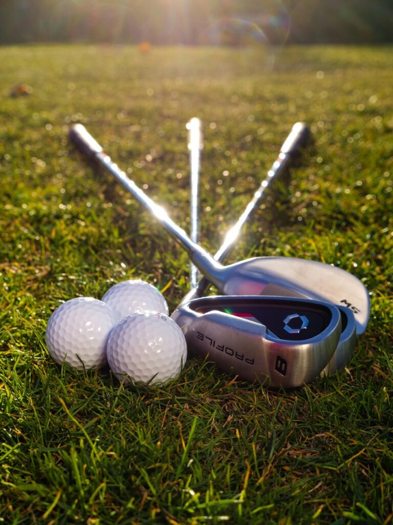 aerospace Golf clubs and balls arranged on a sunlit grass field, perfect sports imagery.