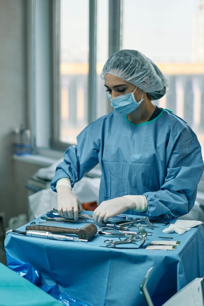 automotive A female surgeon wearing protective gear arranges surgical instruments in a hospital operating room.